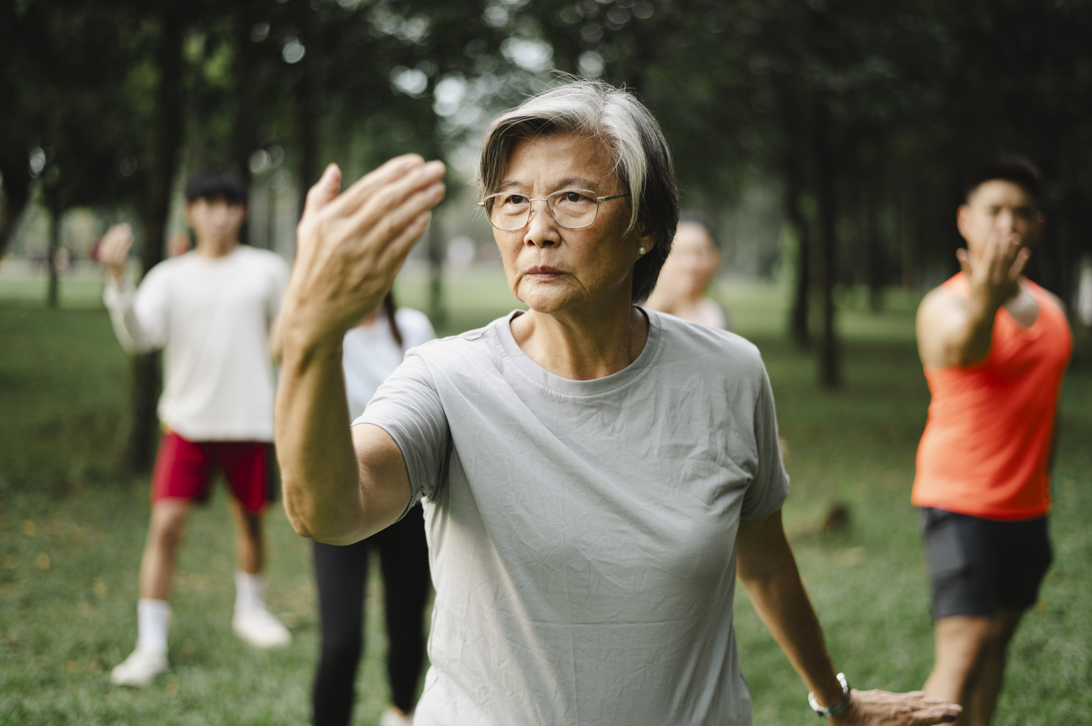 Active senior mother teaching her family Tai Chi.